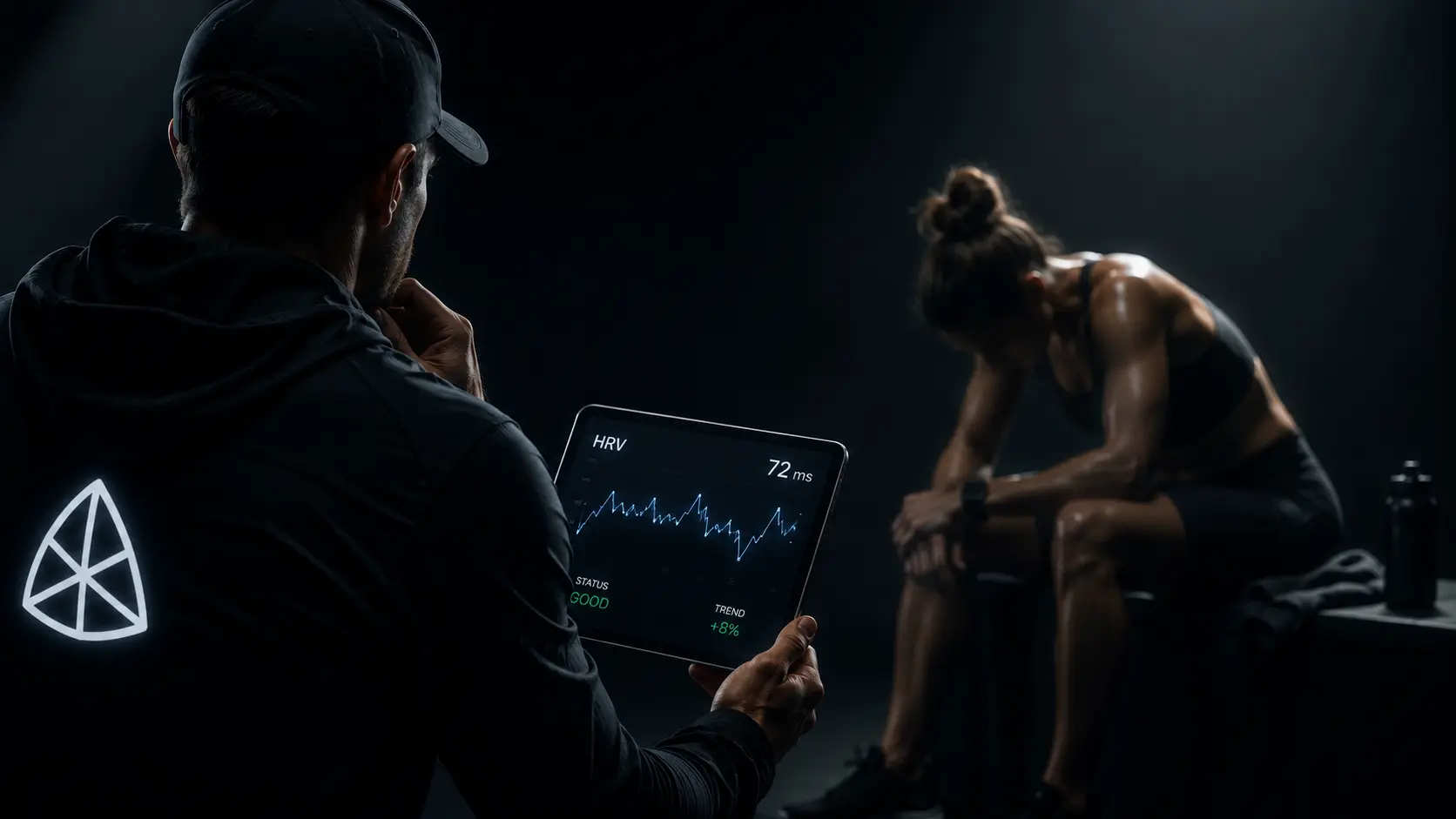 Coach reviewing athlete HRV data on tablet showing 72ms and good recovery status after training session